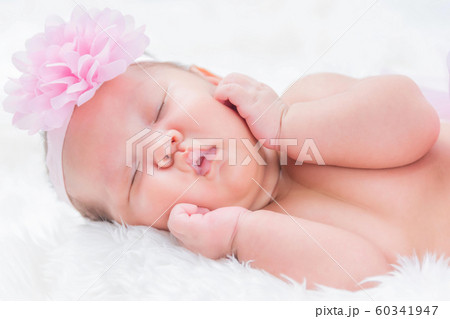 Cute newborn baby lies swaddled in a white 60341947