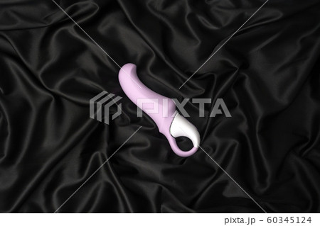 Purple sex toy on a black silk background. Purple sex toy on a black silk background. 60345124