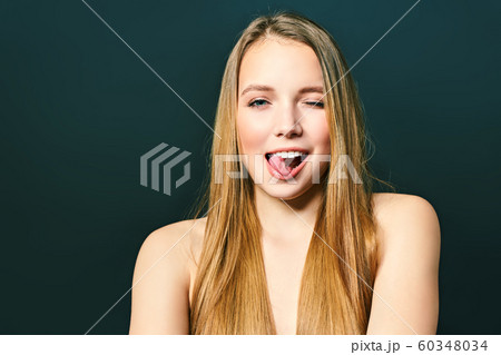 Young crazy lady. Music lover rock fan concept. Close up photo portrait of excited funky funny comic cheerful lady making stick tongue out sign isolated on a black background Young crazy lady. Music lover rock fan concept. Close up photo portrait of excited funky funny comic cheerful lady making stick tongue out sign isolated on a black background 60348034