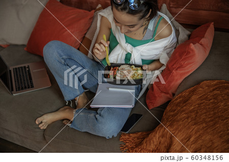 Pretty lady sitting with notebook and food 60348156
