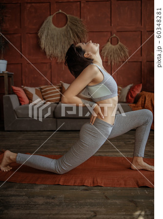 Young lady id doing yoga pose in room 60348281