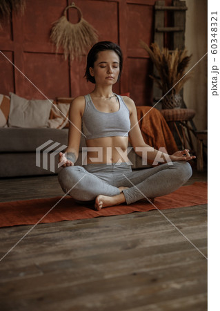 Young woman practicing the art of meditation at home Young woman practicing the art of meditation at home 60348321