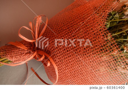 Bouquet of flowers Packed in red mesh for floristry, close-up, open frame Bouquet of flowers Packed in red mesh for floristry, close-up, open frame 60361400