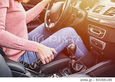 Female hand pulling handbrake in the car. Woman driving car Female hand pulling handbrake in the car. Woman driving car 60366186