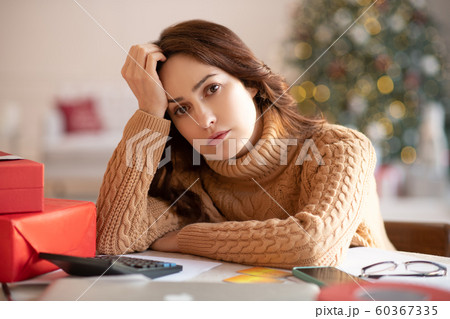 Dark-haired woman in knitted sweater feeling tired 60367335