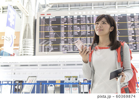 空港 ロビー 掲示板 女性 携帯電話の写真素材