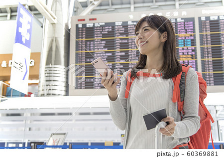 空港 ロビー 掲示板 女性 携帯電話の写真素材