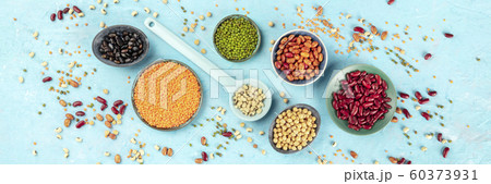 Legumes panorama, top-down shot on a blue background. Vibrant pulses including colourful red and black beans, lentils, soybeans, chickpeas, a flat lay Legumes panorama, top-down shot on a blue background. Vibrant pulses including colourful red and black beans, lentils, soybeans, chickpeas, a flat lay 60373931