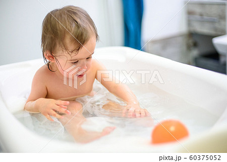 1 year old Baby in bathtub taking bath in bathroom 1 year old Baby in bathtub taking bath in bathroom 60375052
