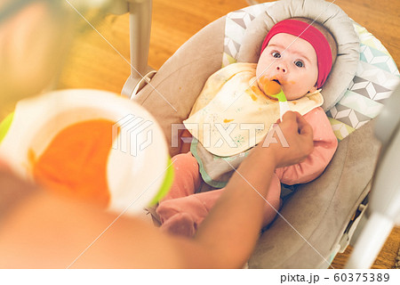 Mother feeding hungry five month old funny baby Mother feeding hungry five month old funny baby 60375389