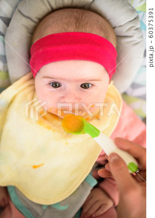 Mother feeding hungry five month old funny baby Mother feeding hungry five month old funny baby 60375391
