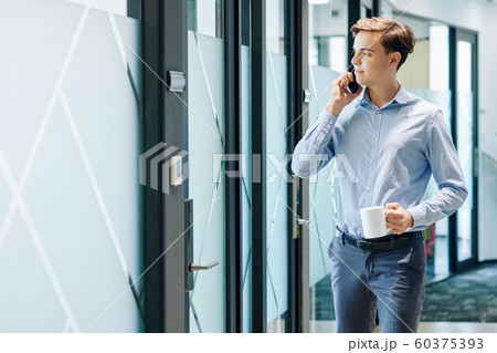 Young businessman with mug of coffee 60375393