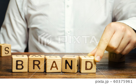 Businessman puts wooden blocks with the word Brand. Business, marketing, and advertising. Name, term, design, symbol that identifies one seller's good or service. 60375961