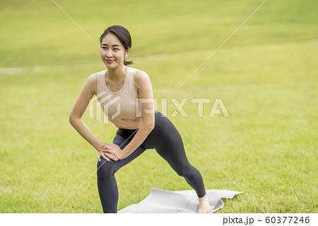芝生の公園でストレッチする女性 芝生の公園でストレッチする女性 60377246