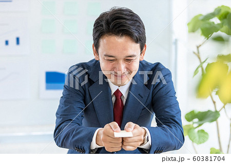 腰が低いビジネスマン　名刺交換　胸の高さ 60381704