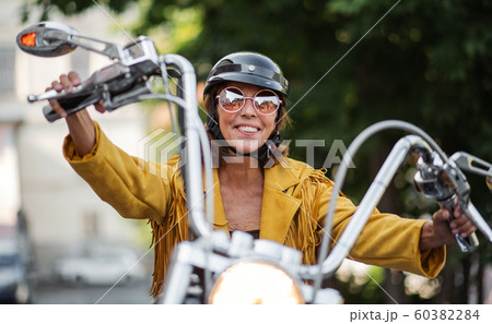 Cheerful senior woman traveller with motorbike in town. Cheerful senior woman traveller with motorbike in town. 60382284