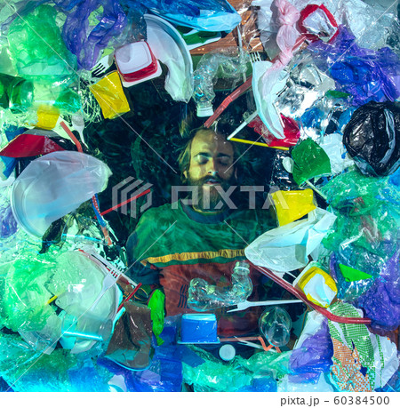 Man drowning in ocean water under plastic recipients pile, environment concept 60384500