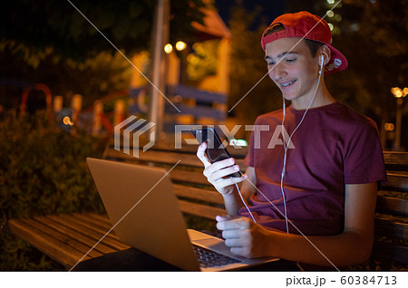 Portrait of a smiling young man with a smartphone, 60384713