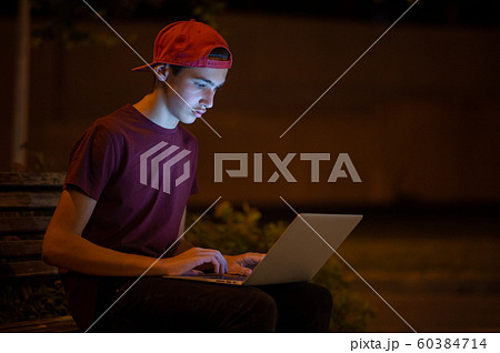 Teenage boy with a laptop in the park. Handsome Teenage boy with a laptop in the park. Handsome 60384714