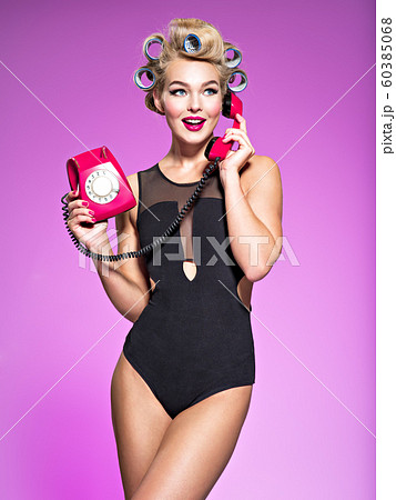 Young cheerful woman calling by retro phone. 60385068