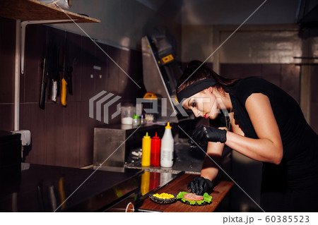 woman chef in the kitchen preparing a hamburger sandwich 60385523