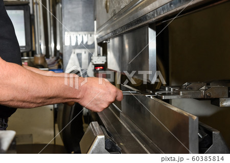 worker operating metal press machine at workshop. worker operating metal press machine at workshop. 60385814