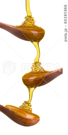 Set of wooden spoon with falling and flowing honey on them isolated on white 60385966