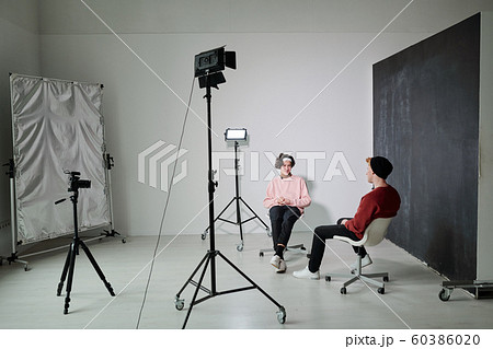 Two young friendly vloggers discussing contemporary fashion trends in studio 60386020