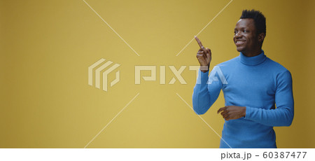 Smiling young man pointing right 60387477