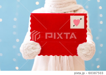 Young woman holding a big Valentine's day envelope 60387503