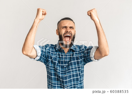 Freestyle. Guy in checkered shirt standing isolated on white hands up screaming excited Freestyle. Guy in checkered shirt standing isolated on white hands up screaming excited 60388535