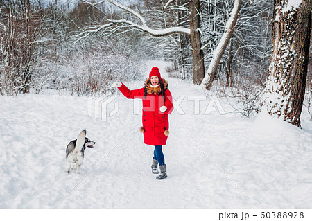 Young woman playing with her Husky dog in winter park 60388928