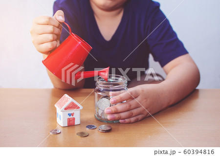 Boy watering House and coins. plan for House Boy watering House and coins. plan for House 60394816