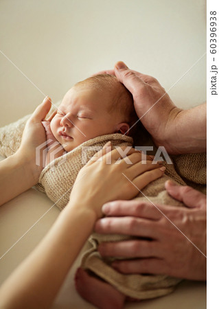 Cute newborn baby girl lying on her father's and mother hands, at home 60396938