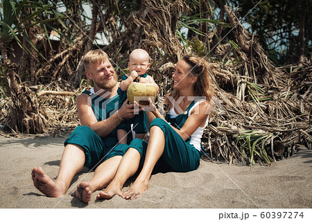 Happy family have funny picnic on beach - drink 60397274