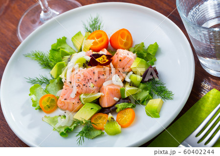 Ceviche from salmon on plate with cumquat, green dill and avocado 60402244