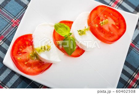 Salad caprese with tomatoes, mozzarella cheese and herbs Salad caprese with tomatoes, mozzarella cheese and herbs 60402508