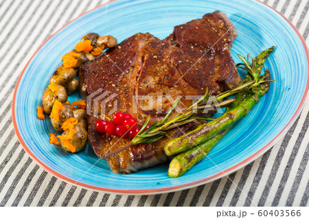 Steak entrecote of beef with mushroom and asparagus at plate 60403566