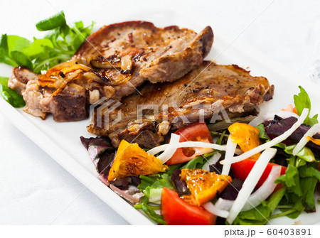 Grilled pork chop with salad 60403891