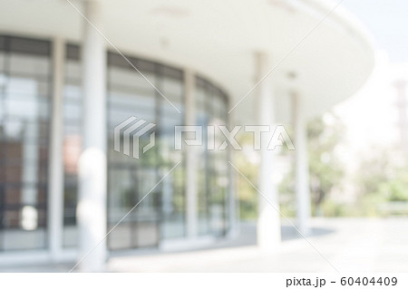Blur office background building exterior view to lobby glass window wall with blurry light bokeh 60404409