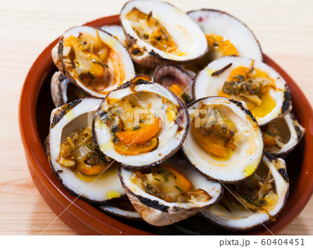 Tasty open dog cockle baked in oven, served at white plate on table 60404451