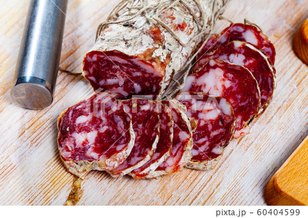 Piacenza salami cut in slices on a wooden surface, close-up Piacenza salami cut in slices on a wooden surface, close-up 60404599
