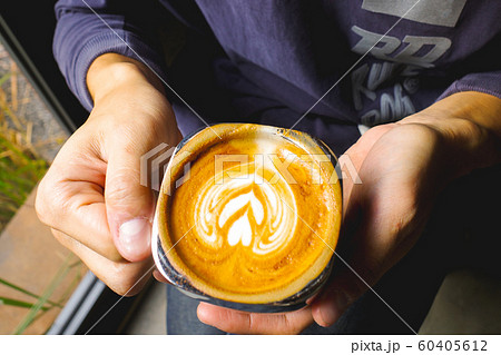 Close-up of man holding a hot latte coffee Close-up of man holding a hot latte coffee 60405612
