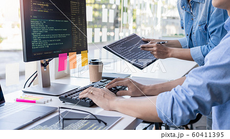 Pensive programmer working on on desktop pc 60411395