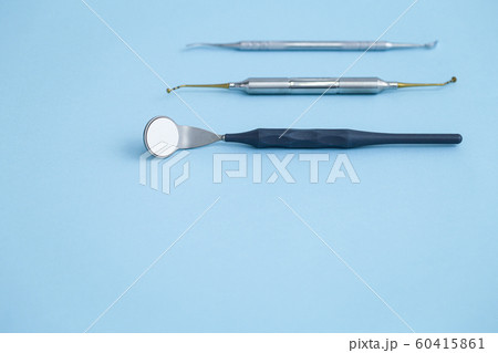 Closeup of set of dental instruments on blue background Closeup of set of dental instruments on blue background 60415861