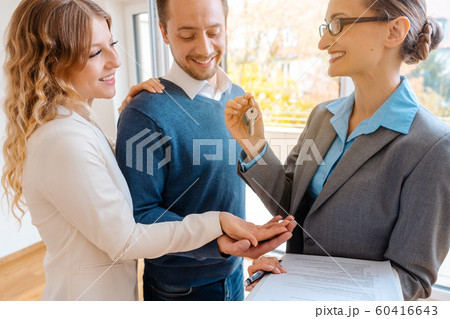 Realtor giving house key to the buyers or tenants Realtor giving house key to the buyers or tenants 60416643