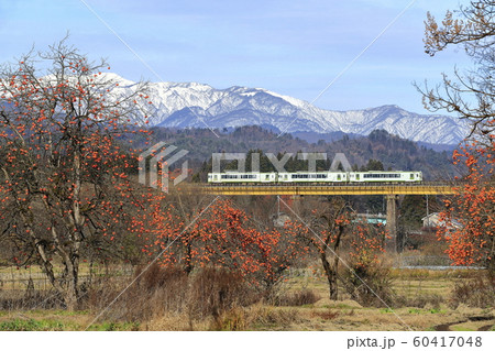 晩秋の磐越西線と雪化粧の飯豊連峰 60417048