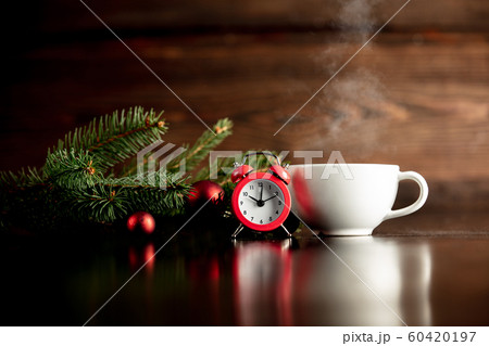 Red alarm clock and cup of hot drink on wooden table Red alarm clock and cup of hot drink on wooden table 60420197