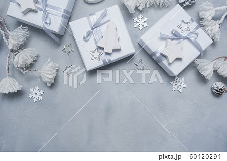 Border Design a Christmas greeting card with Xmas gift box, cones, snowflakes with place for your text. Decorations on a white concrete background 60420294