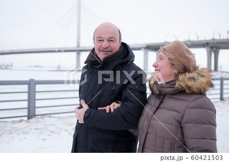 Senior couple walking together on snowy landscape Senior couple walking together on snowy landscape 60421503